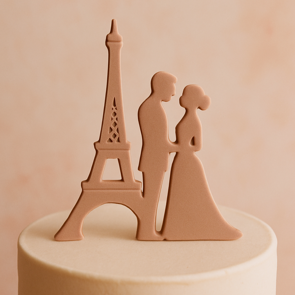 An Eiffel Tower silhouette topper stands beside a couple figurine on a wedding cake.